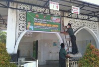 Babinsa koramil 07 kampar pasang spanduk di mesjid cegah virus corona